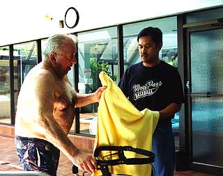 Guy at swimming pool receiving a towel